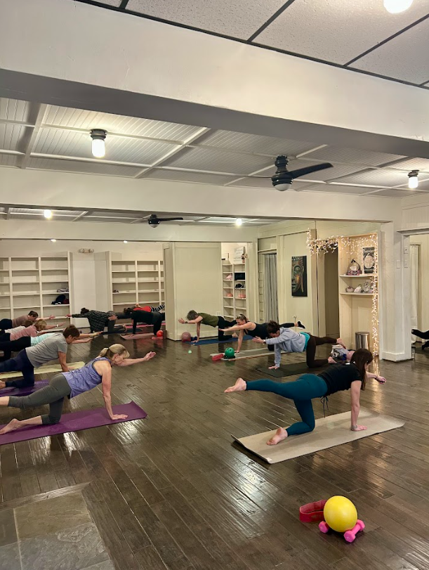 A team of athletes seated on mats and ready for a private group class at Hereford Barre